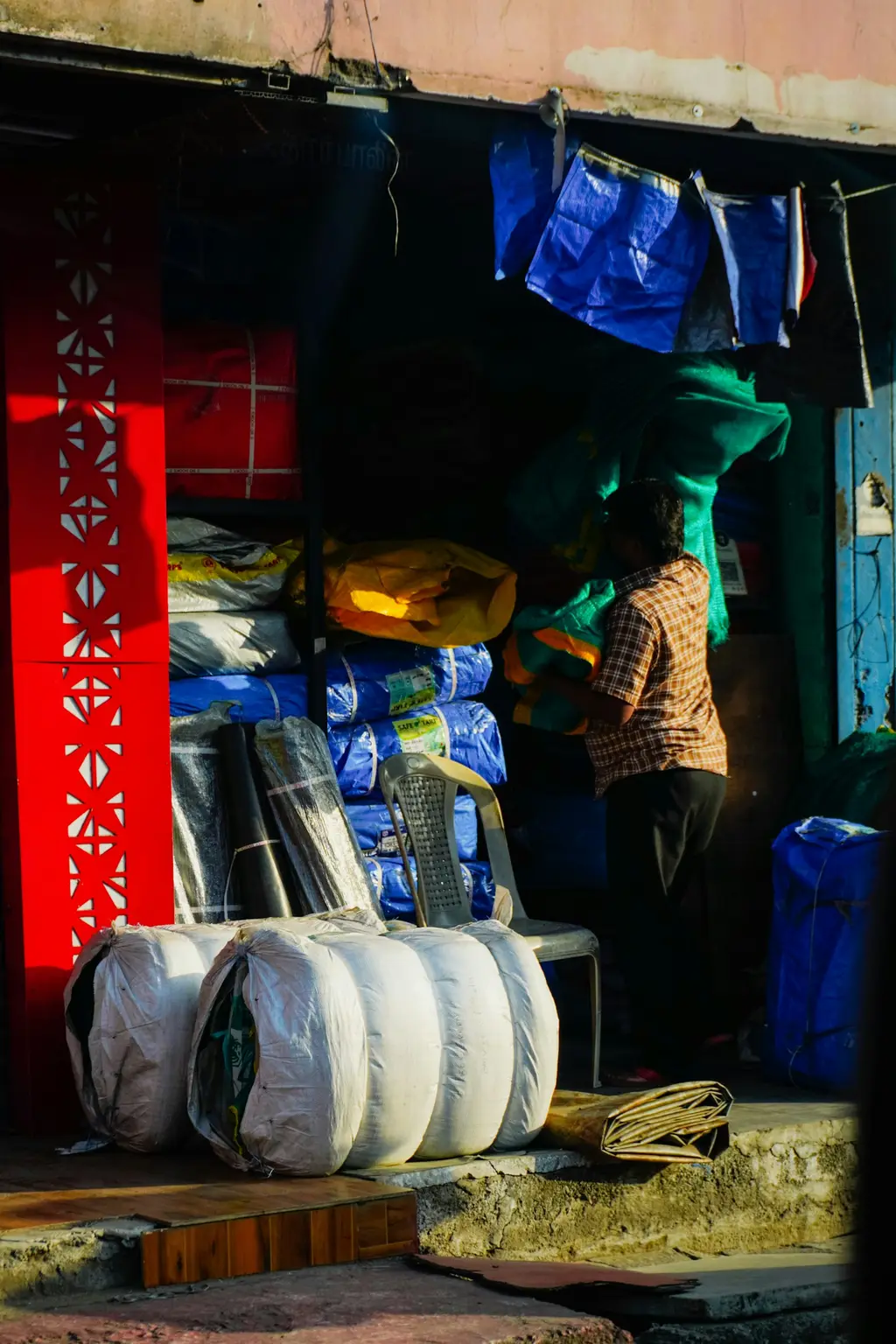 Rolls of tarpaulin sheet stacked in a store